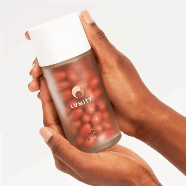 Woman’s hand holding Lumity Morning and Night Female Refill softgel capsules in transparent pack