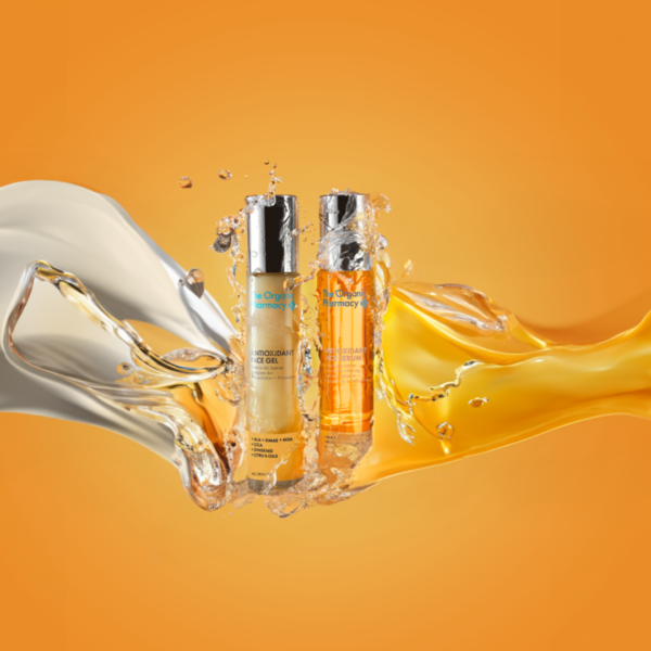 Artistic splash effect of The Organic Pharmacy Antioxidant Duo serums captured in motion against a clean background