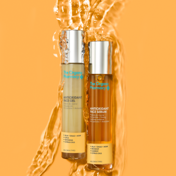 Inspiring artful image of The Organic Pharmacy Antioxidant Duo 2x35ml bottles set against a vibrant orange background, evoking energy and vitality