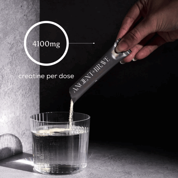 Ancient and Brave True Creatine sachet being poured into a glass of water, delivering 4100mg creatine per dose for enhanced performance and recovery