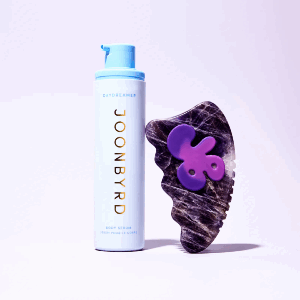 Joonbyrd Daydreamer Firming Body Serum 100ml bottle displayed next to a gua sha tool, highlighting skin-firming and nourishing benefits.