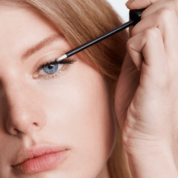 Woman applying M2 Beauté Eyelash Awakening Serum 4ml to eyelashes, promoting lash growth, strength, and density.