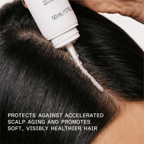 Woman applying Olaplex No 5 Fine Bond Maintenance Conditioner to mid-lengths of damp hair, showcasing shine, softness, and volume boost for fine hair