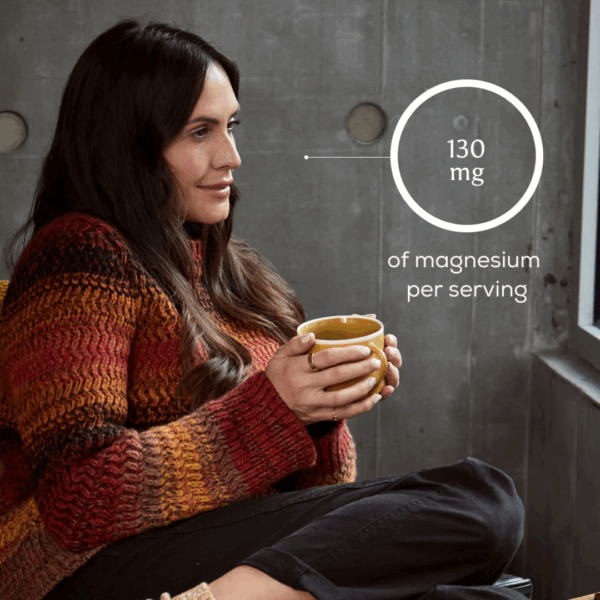 Woman holding a cup of True Nightcap drink made with Ancient and Brave supplement, featuring 130mg magnesium per serving