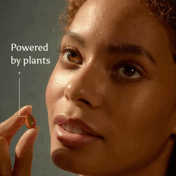 Woman holding a True Omegas+ capsule, representing plant-based omega support from Ancient and Brave