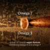 Close-up of Ancient and Brave True Omegas+ capsule highlighting omega 3, omega 7, and first-of-its-kind vegan formula