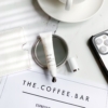 Teoxane 3D Lip 10ml placed beside an iPhone and a cup of coffee on a stylish surface, capturing a modern, on-the-go beauty routine