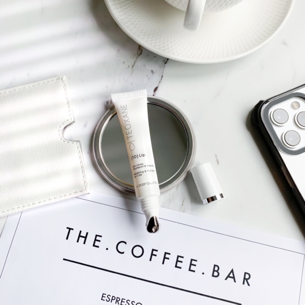 Teoxane 3D Lip 10ml placed beside an iPhone and a cup of coffee on a stylish surface, capturing a modern, on-the-go beauty routine