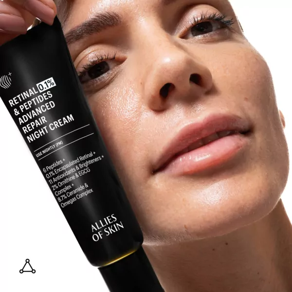 Woman holding Allies Of Skin 0.1% Retinal And Peptides Advanced Repair Night Cream near her face, highlighting product for night skin renewal
