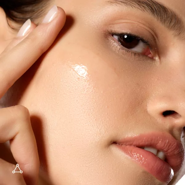 Woman applying Allies Of Skin The One SPF 50 Invisible Sunscreen Gel to her face for daily broad-spectrum sun protection