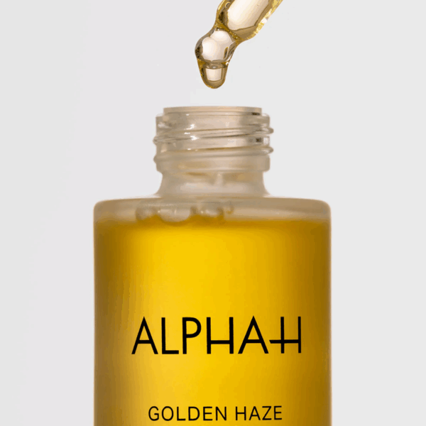 Close-up of Alpha H Golden Haze Face Oil 25ml dropper showing rich golden texture for radiant and nourished skin.