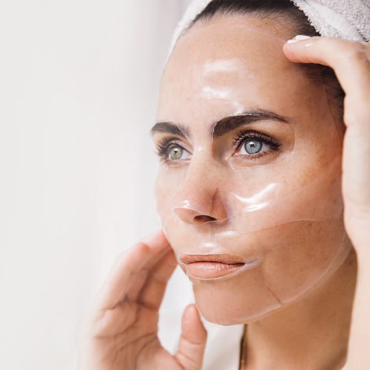 Woman applying Bioeffect Imprinting Hydrogel Mask on her face; pack of 6 hydrogel masks designed for deep hydration and skin rejuvenation.