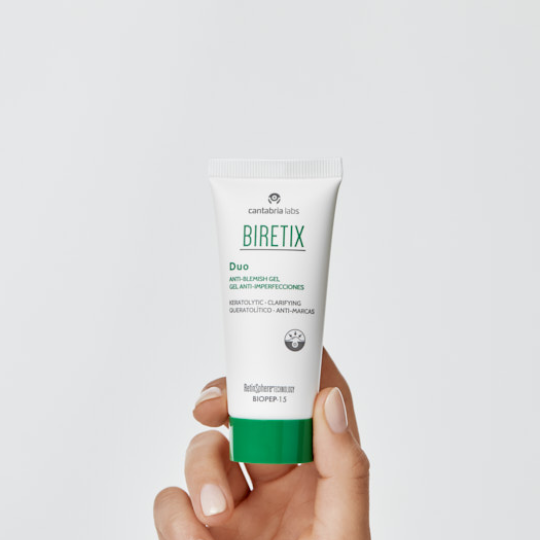 A close-up image of a hand holding a BiRetix Duo Anti-Blemish Gel 30ml tube, showing the product packaging designed for acne-prone skin.