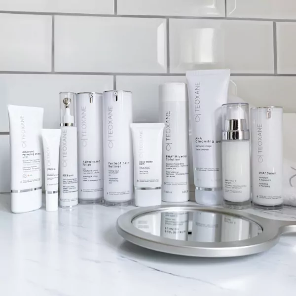 Collection of Teoxane skincare products arranged aesthetically on a neutral background, representing advanced dermocosmetic care
